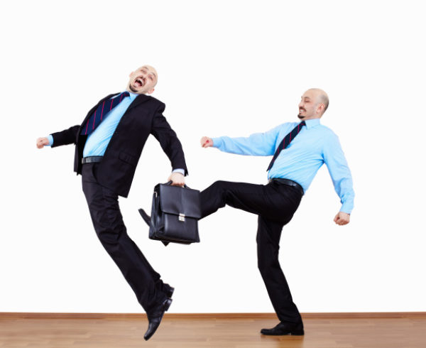 coworker kicking coworker with briefcase