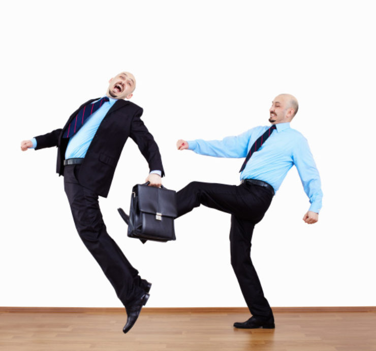 coworker kicking coworker with briefcase